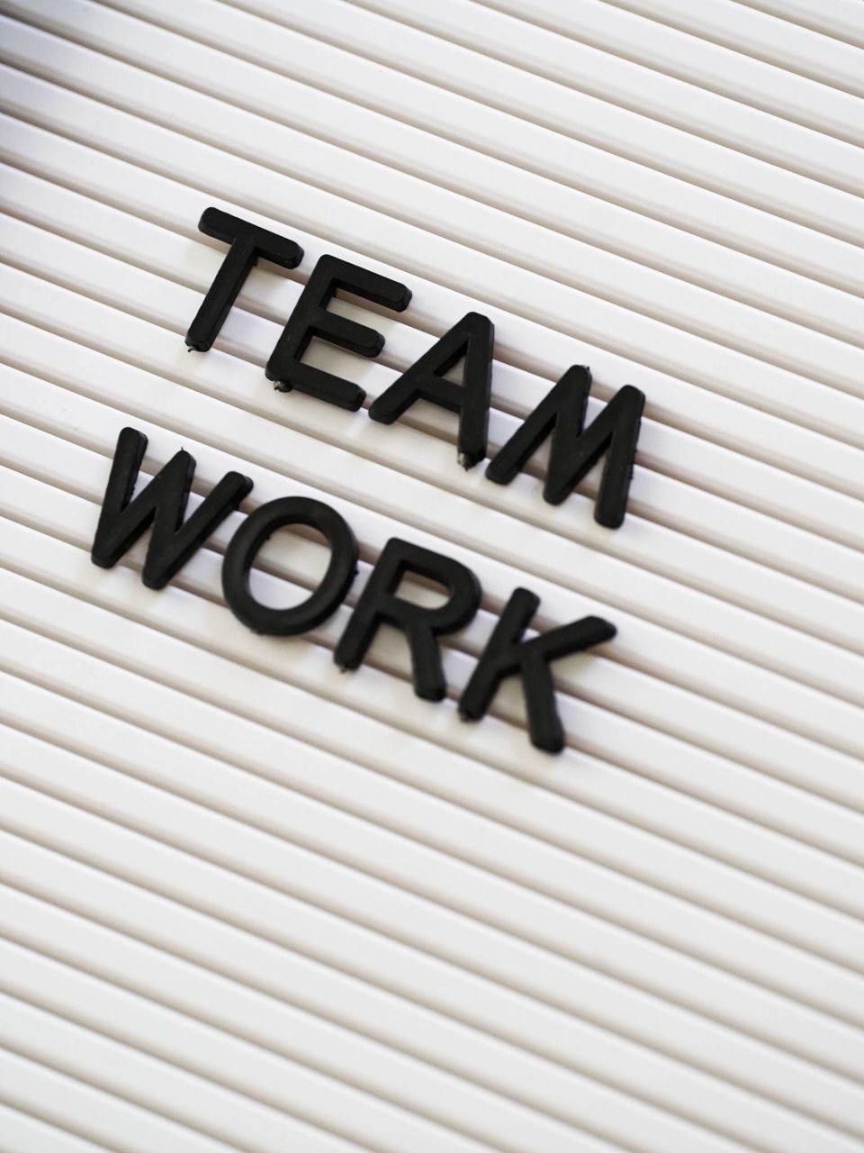 Das Bild zeigt einen weißen Hintergrund, auf dem der Schriftzug „Teamwork“ in 3D aufgesteckt ist. Dieses Bild symbolisierte die Zusammenarbeit mit dem AAT-Marketingteam hinsichtlich gemeinsamer Werbung.